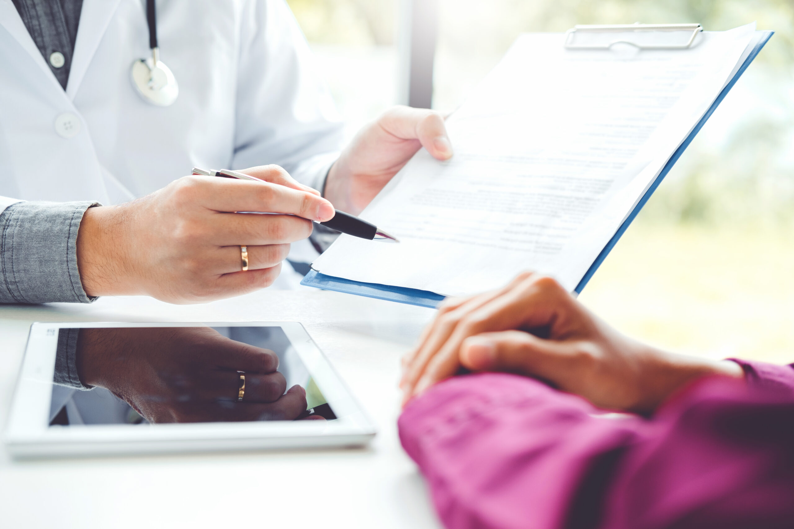 Doctors and patients sit and talk. At the table near the window in the hospital.